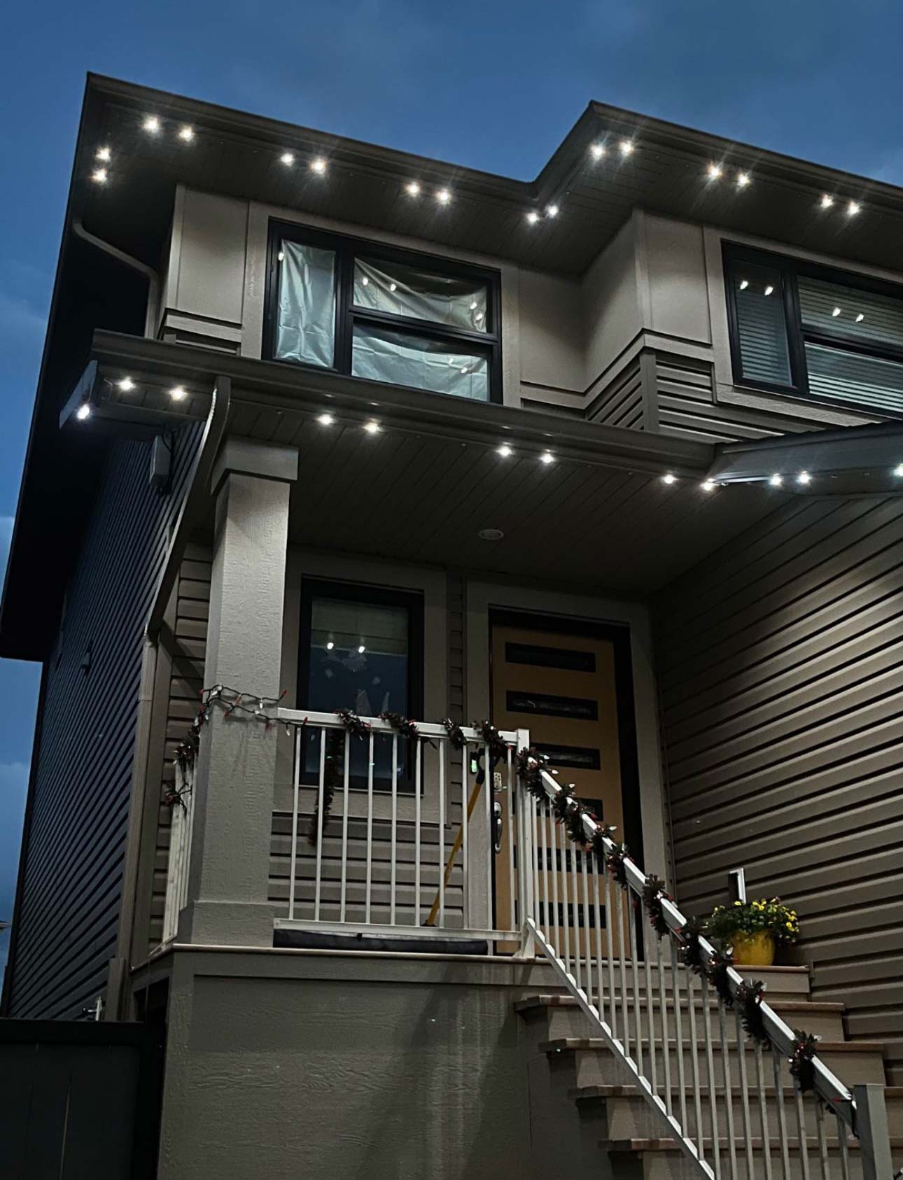 image_123986672-(4) Modern home exterior at night with bright LED lights accentuating the roofline and entryway, creating a clean and contemporary look under the evening sky.