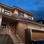 Modern two-story home at dusk, featuring clean architectural lines and bright LED lighting along the roofline, accentuating the house's exterior details and creating a welcoming atmosphere.